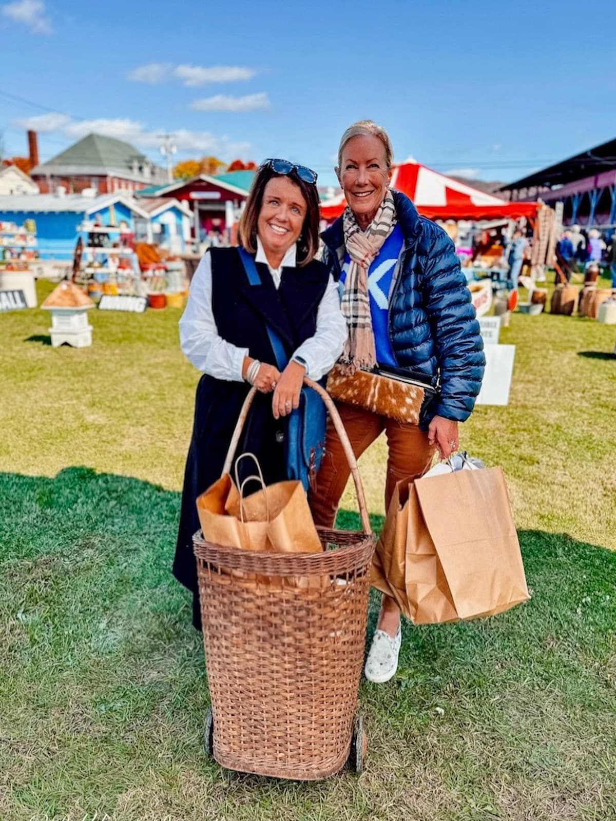 Two women with vintage basket and bags of antiques at Vintage Market Days Vermont.