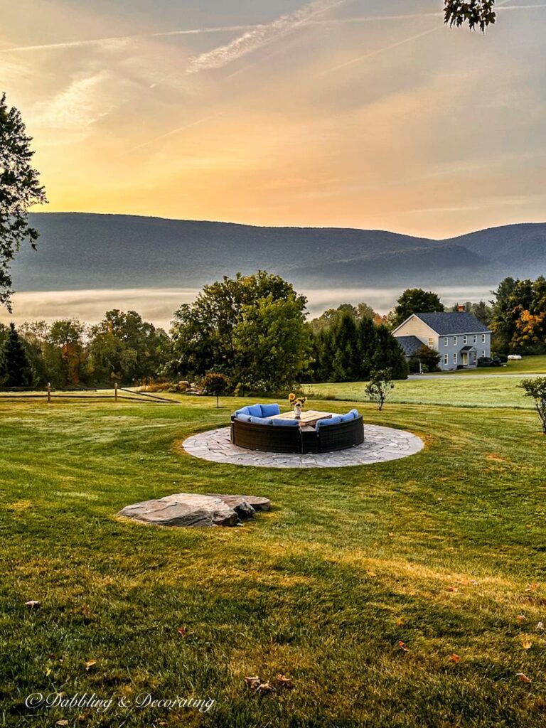 Round fire pit patio in the Vermont mountains in early morning fall dew.