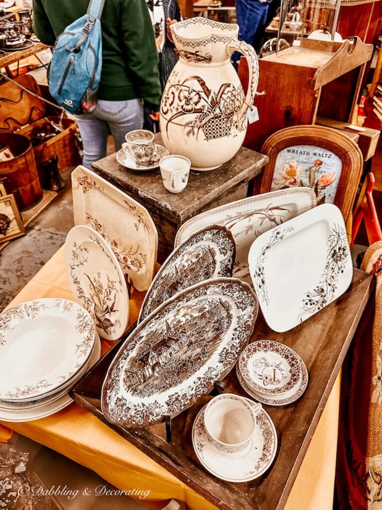 Brown and white antique transferware displayed at market.