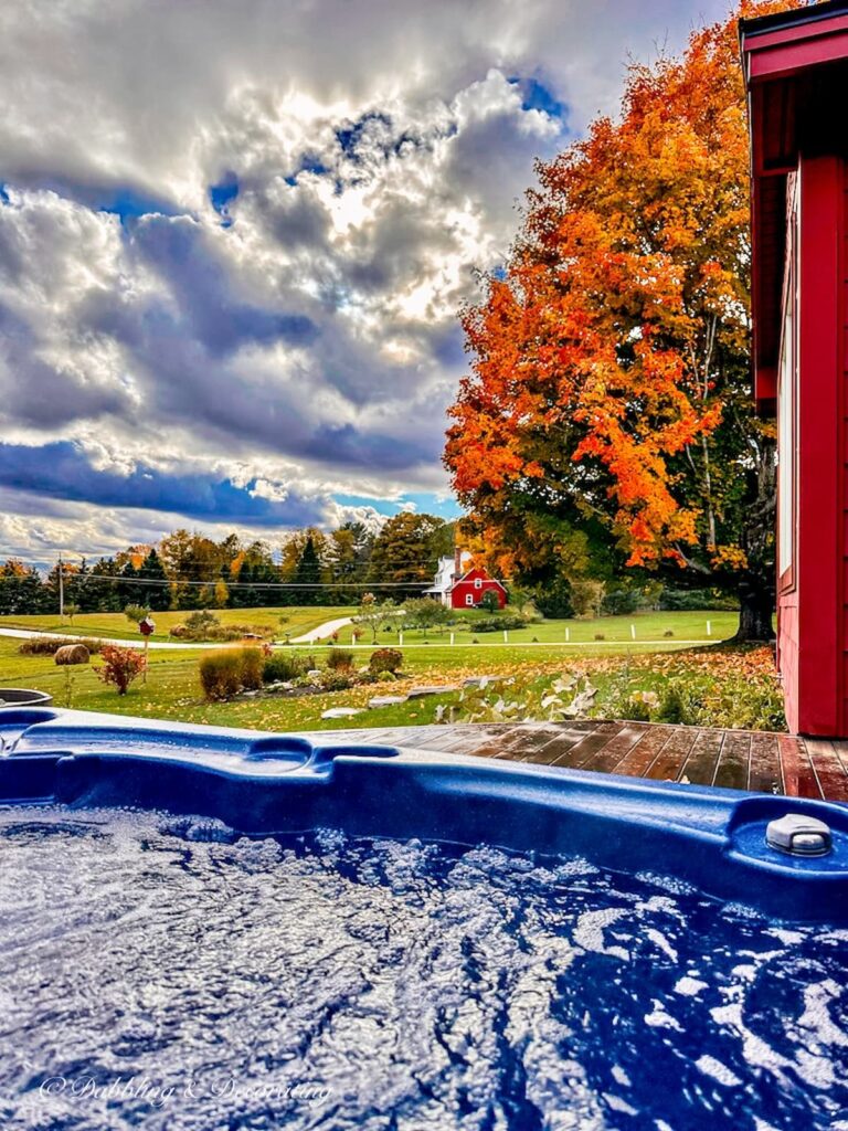 Vermont fall foliage view from open hot tub onto Maple tree that is orange.