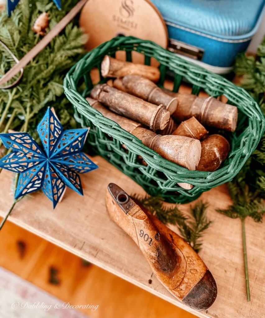 Green basket filled with decorative wood spindles cut small on table.