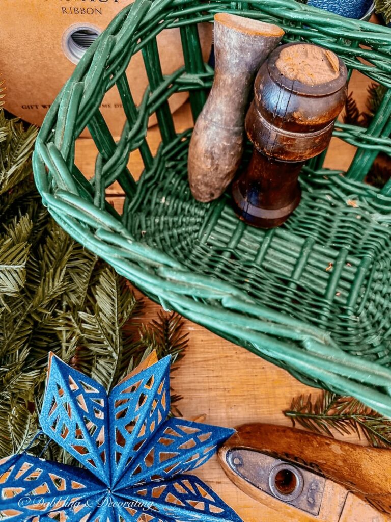 Two decorative wood spindles in green basket. One finished and one unfinished.