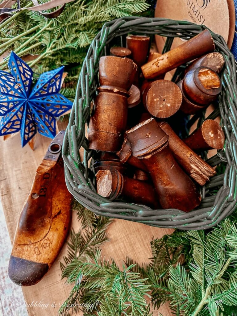 Basket full of polished decorative wood spindles on Christmas craft table.