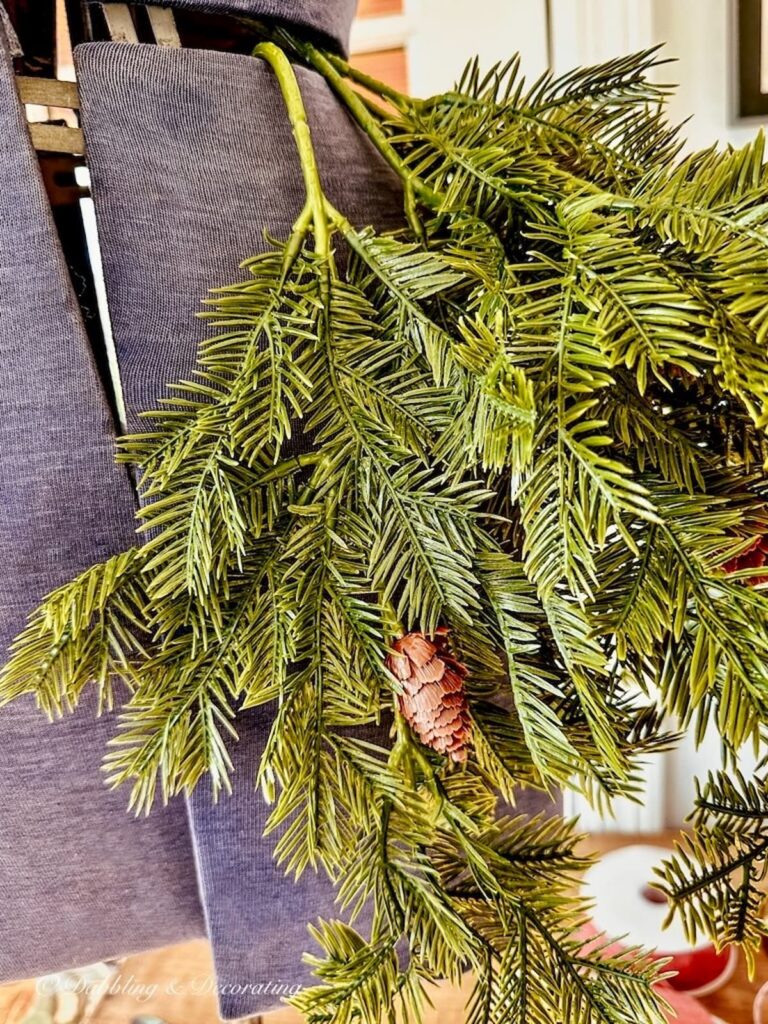 Faux evergreen branches close up on mannequin.