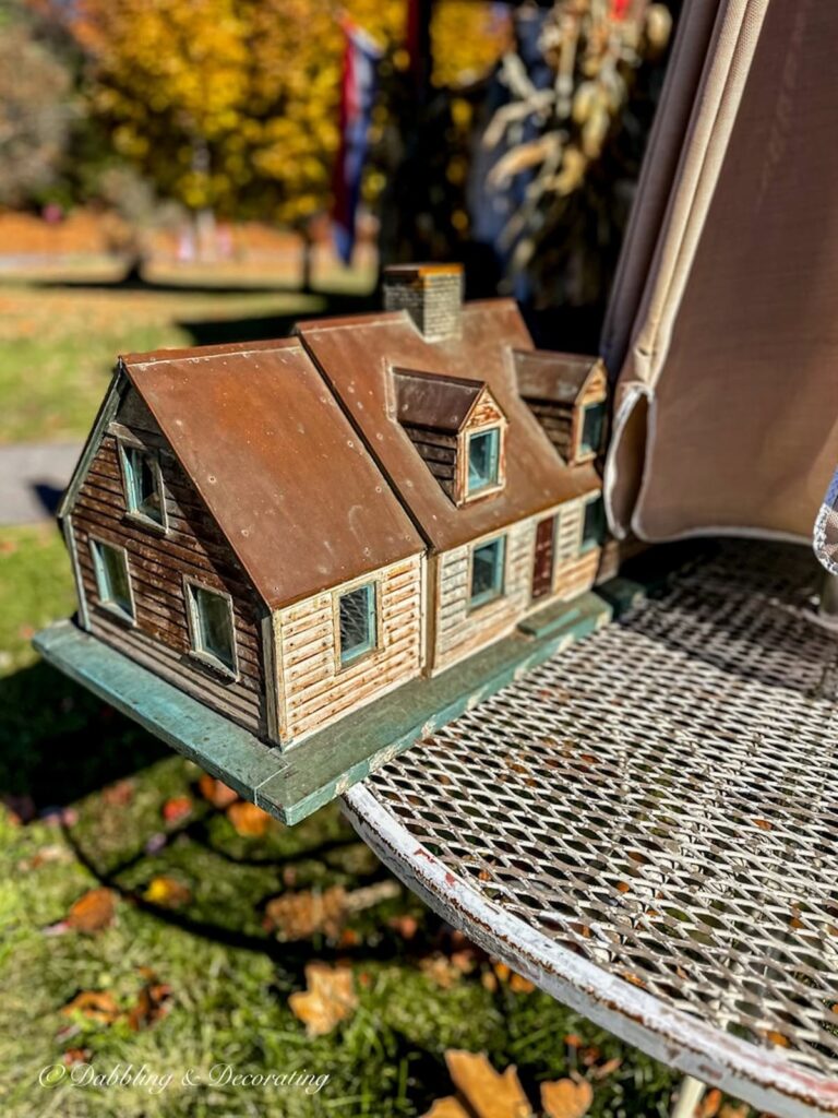 Cedar Shakes doll house looking mailbox on outdoor table.