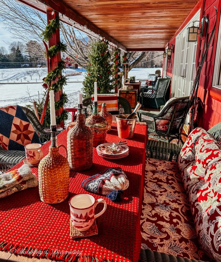 Après Ski Theme Party table with cozy red Christmas vibes and snow on porch.