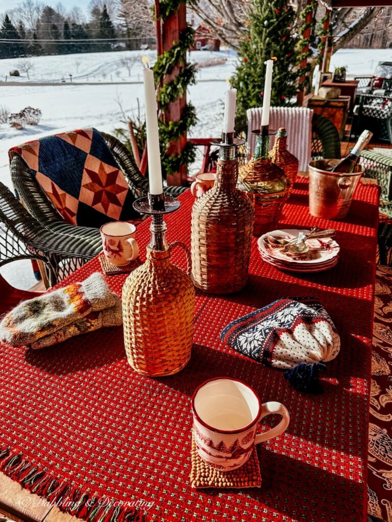 Après Ski Theme porch table with demijohns, candles and hot cocoa.