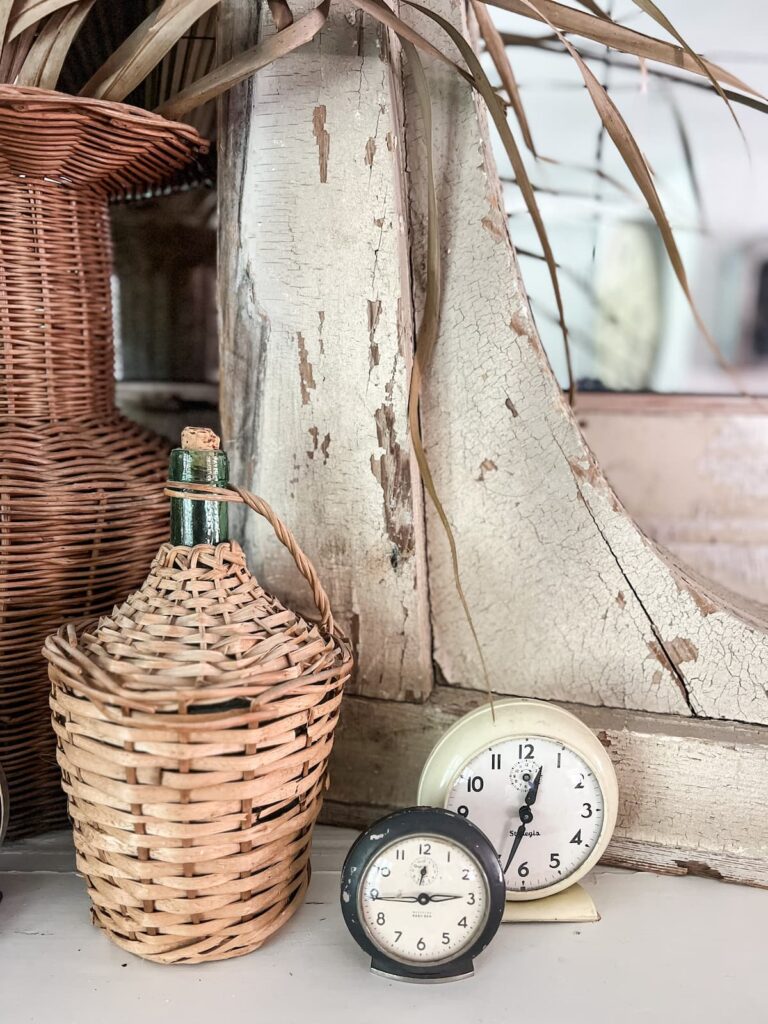 Vintage demijohn, alarm clocks, and corbels.