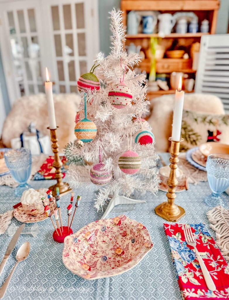 Vintage white small Christmas tree on light blue tablescape with Christmas Simple winter table decorations.