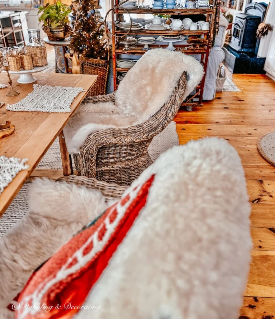 Sheepskins on wicker chairs for simple winter table decorations in dining room.