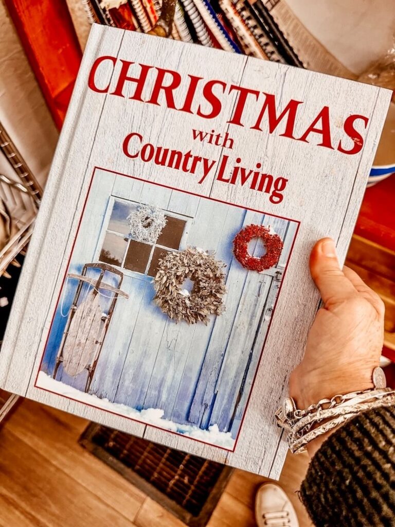 Christmas with Country Living Book in hand at thrift shop.