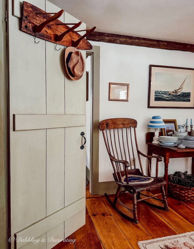 Antique style dining room with open pantry day with DIY coat rack hanging on open door.