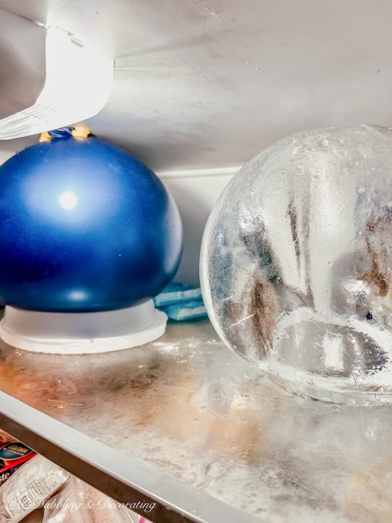 Ice lantern blue balloon filled with water in freezer and one ice lantern frozen without balloon.