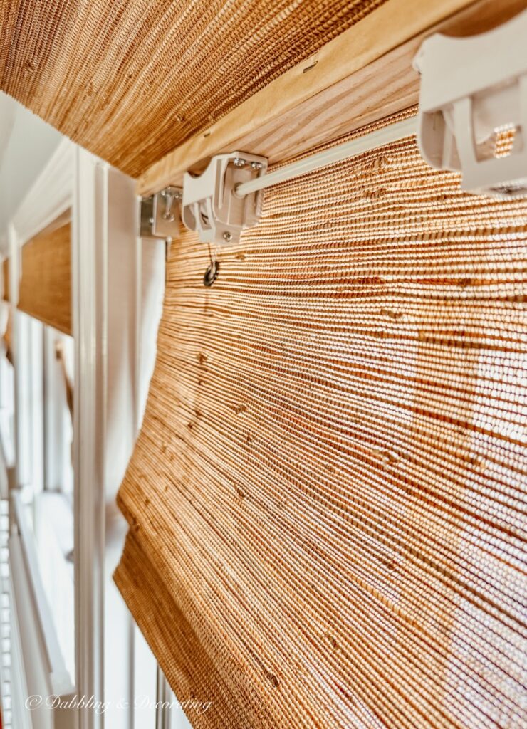 Close up of bamboo shade installation hardware on window.