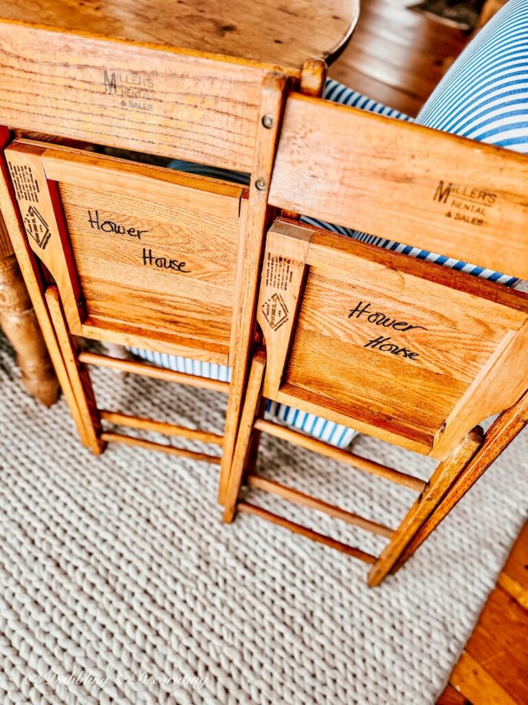 Two vintage small folding woodenchairs with the words Hower House written on the bottom.