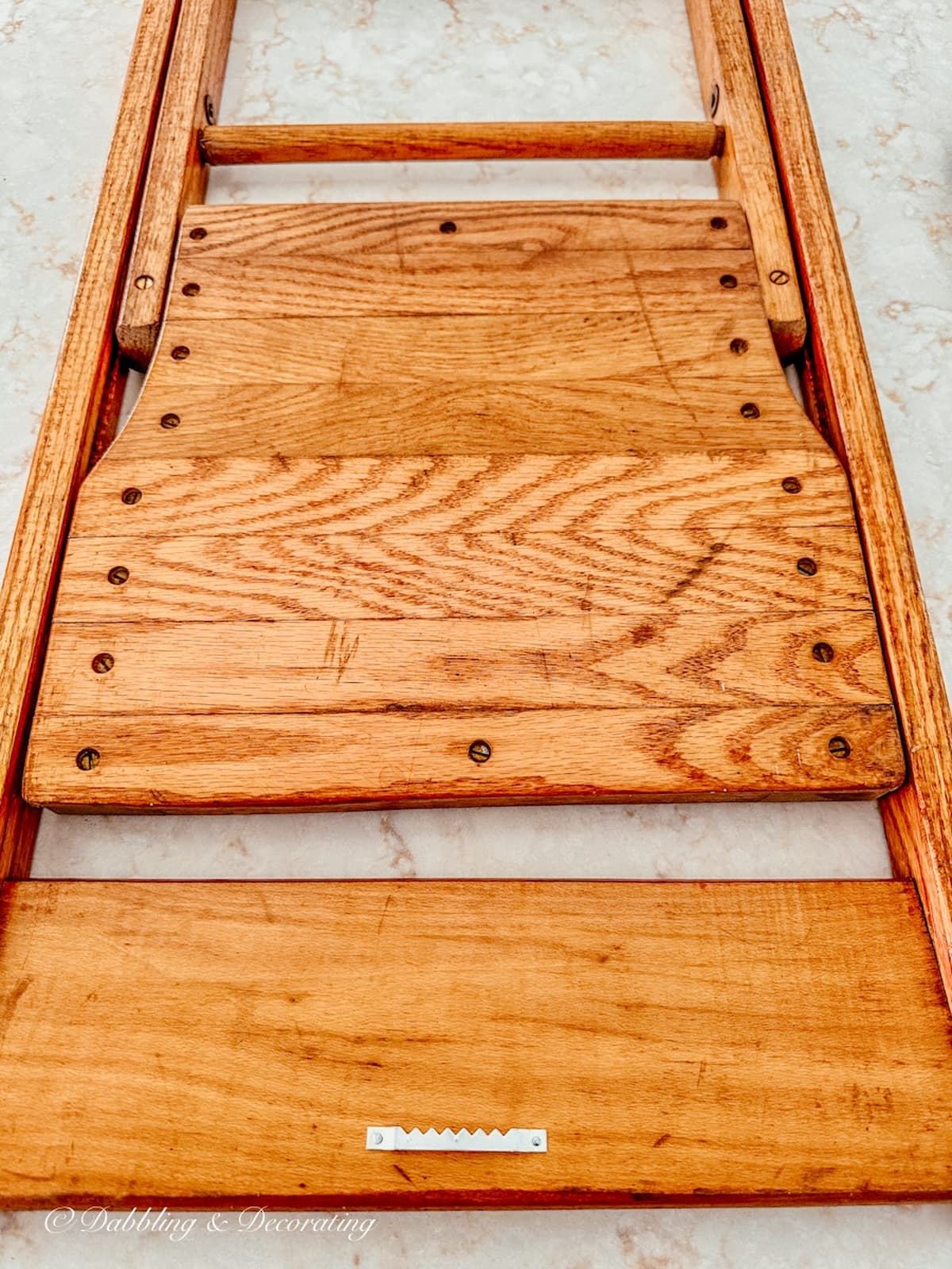 Vintage oak chair with sawtooth hook installed on front of vintage wood folding chair to hang in vintage wall decor.