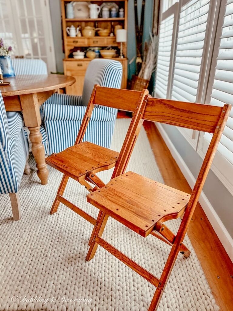 Two wooden retro folding chairs in dining room space for vintage wall decor.