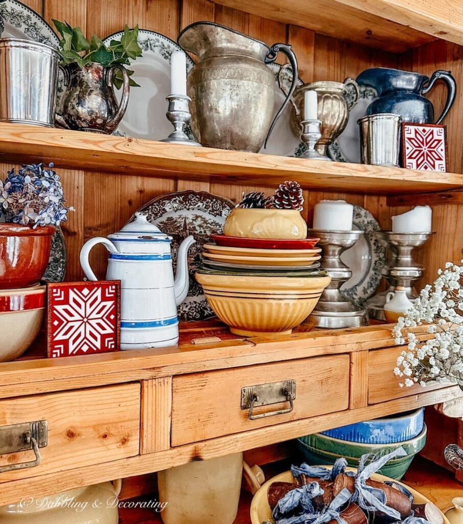 Vintage Styled hutch with two red and white snowflake vintage wall decor art pieces.