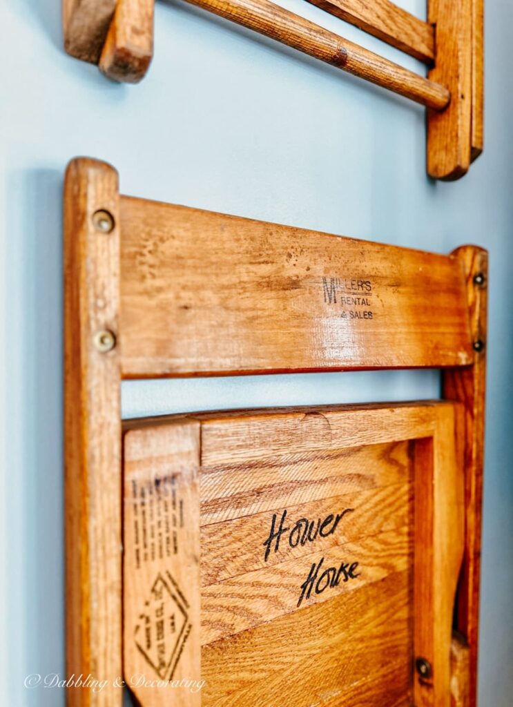 Old Oak chair with Hower House written hanging on blue wall.