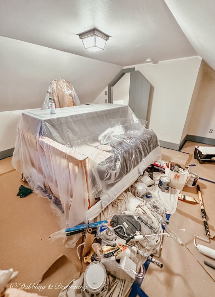 Attic bedroom with slanted ceilings with white walls and painting preparations Before.