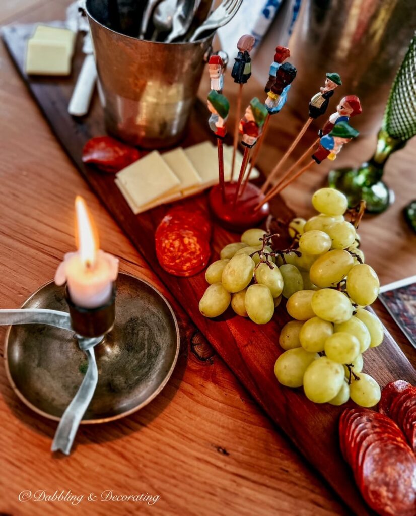 Antique trapper fur stretcher made into charcuterie board with lit candle on table.