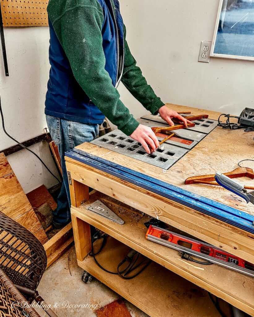 Person at workbench with electric saw sawing vintage clothes hanger for DIY Coat Rack