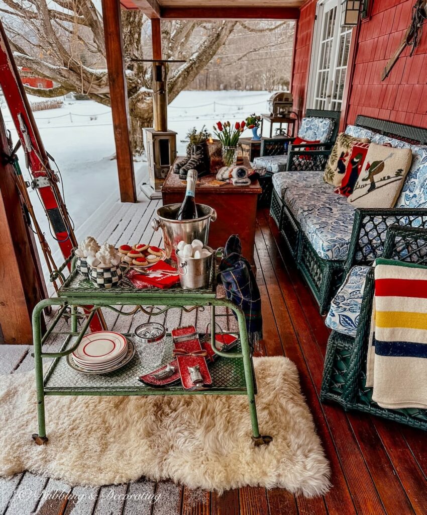 Winter styled porch for apres' ski with an antique bar cart styled for hot chocolate.