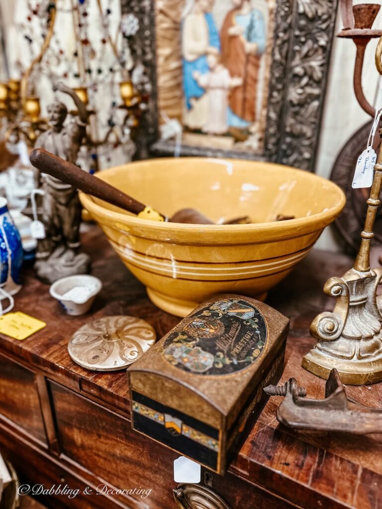 Yellow ware bowl in antique store other vintage items on table.