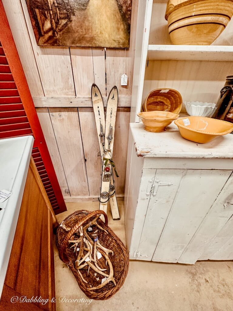 Yellow ware bowls on hutch with other vintage items in antique booth.