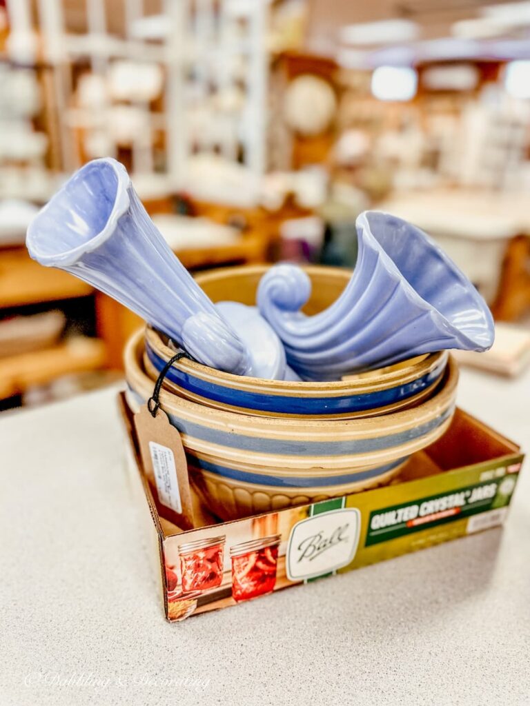 Antique yellow ware bowls in blue bands in box at antique store with two blue McCoy vases.