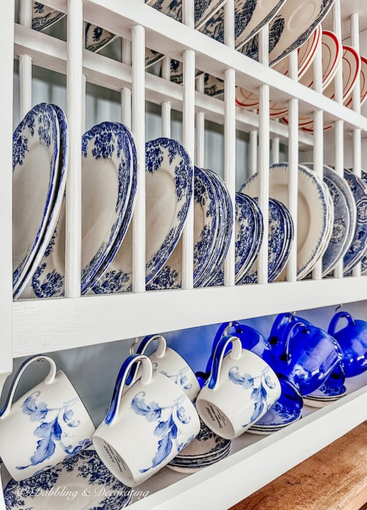 White dish rack in kitchen with blue and white dishes and mugs.