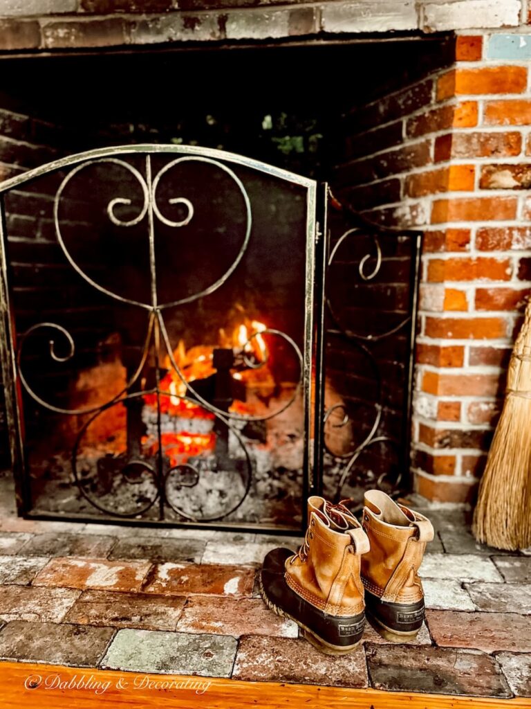 L.L. Bean boots in front of fireplace in eclectic interiors.