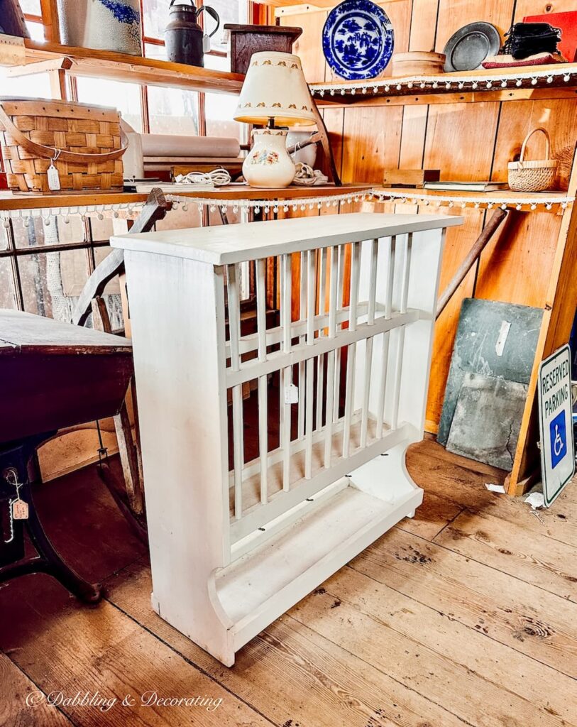 White farmhouse style dish rack in second-hand shop for eclectic interiors.