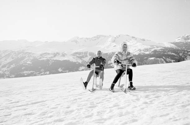 Man and Woman Schibobbing in black and white vintage photo in the mountains.