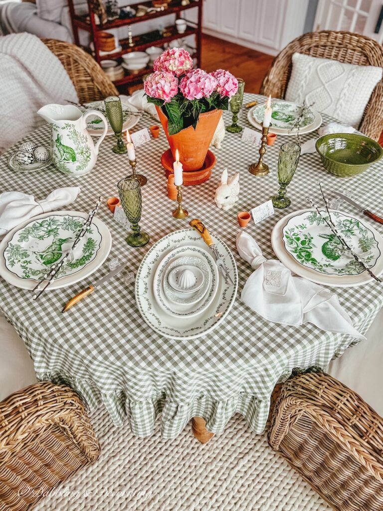 Green and white round tablescape with terracotta decor pot with pink hydrangeas centerpiece for spring.